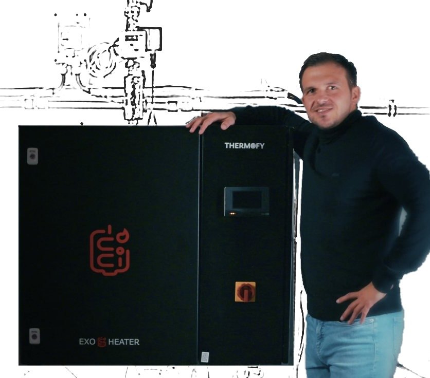 Der ExoHeater im Heizungsraum, daneben ein zufriedener Mann